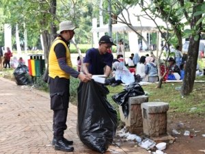 Polisi Bersihkan Sampah Usai Upacara HUT Bhayangkara ke-79 di Monas