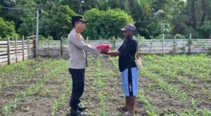 Kapolsek Pantai Timur Polda Papua Bagikan Bendera Merah Putih Kepada Masyarakat